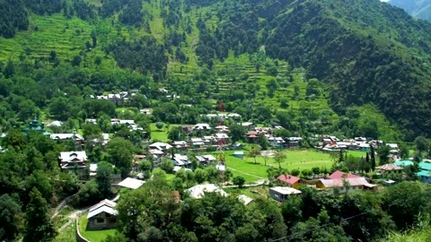 Slow motion shot of beautiful huts and cricket stadium with lush green mount Stock Footage 200744210