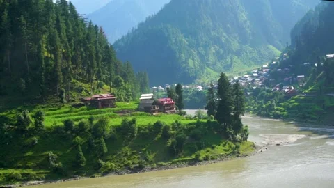Slow motion shot of beautiful huts with lush green mountains and river in hi Stock Footage 200744505