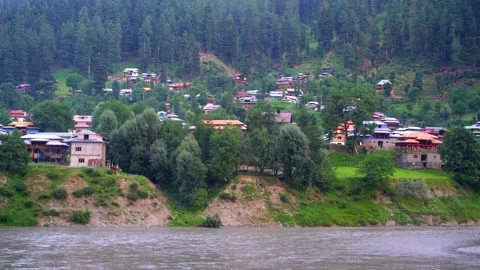Slow motion shot of beautiful huts with lush green mountains and river in hi Stock Footage 200745178