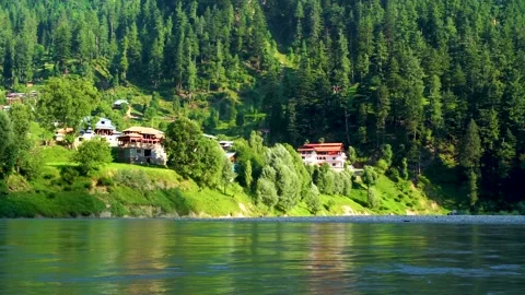 Slow motion shot of beautiful huts with lush green mountains and river in hi Stock Footage 200745181