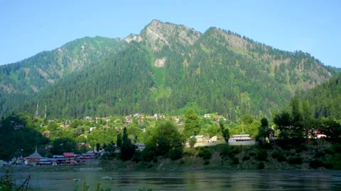 Slow motion shot of beautiful huts with lush green mountains and river in hi Stock Footage 200745398