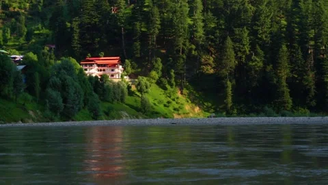 Slow motion shot of beautiful huts with lush green mountains and river in hi Stock Footage 200745409