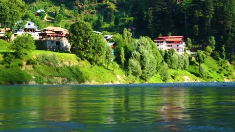 Slow motion shot of beautiful huts with lush green mountains and river in hi Stock Footage 200745412