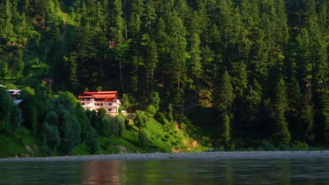 Slow motion shot of beautiful huts with lush green mountains and river in hi Stock Footage 200745413