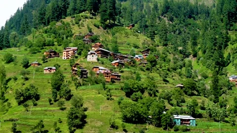 Slow motion shot of beautiful huts with lush green mountains in hilly area o Stock Footage 200746388
