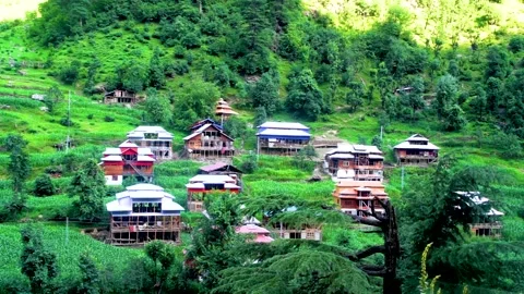Slow motion shot of beautiful huts with lush green mountains in hilly area o Stock Footage 200747022