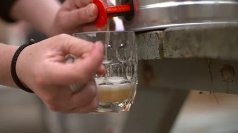 A slow motion shot of beer being poured from a keg on a bench Stock Footage 87857201
