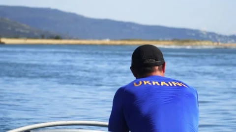 Slow motion shot from behind, of a Paralympic athlete rowing a river on a Stock Footage 233237996