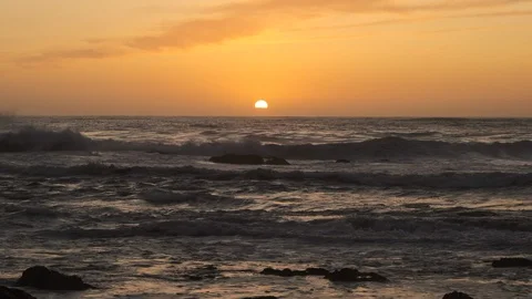 Slow motion shot of big, rough waves on ocean at sunset, with sun on horizon Stock Footage 116581170