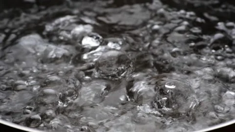 Slow motion shot of boiling water. Bubbles of boiling water background. Cooking Stock Footage