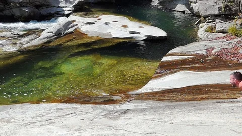 Slow motion shot of boy having fun sliding into the water 動画素材 114178148