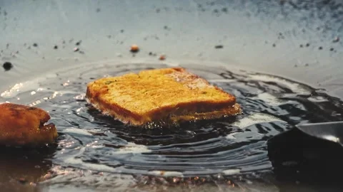 Slow Motion Shot of Bread Frying with Oil Splashes 스톡 동영상 323098714