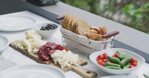 Slow motion shot of breakfast table including cheese plate dry meat black olive  Stock Footage 91009815