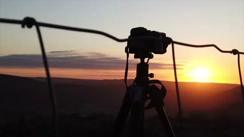 Slow-motion shot of a camera and tripod at sunrise Stock Footage 130469011