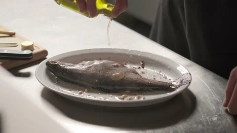 Slow motion shot: Chef adds an olive oil on to the fish. Rainbow trout. 4k. Slow Stock Footage 139152061
