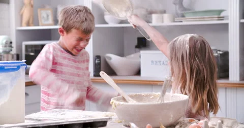 Slow Motion Shot Of Children Having Messy Fun In Kitchen Stock Footage