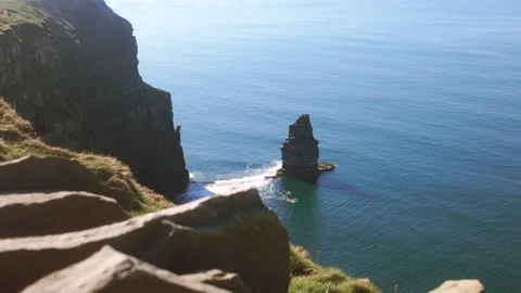 A slow-motion shot of the Cliffs of Moher and a lone sea stack in Ireland Stock Footage 332602130
