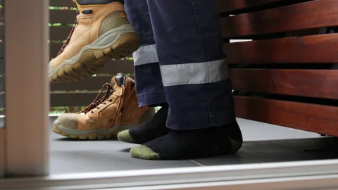 Slow motion shot of construction worker putting on steel cap work boots  Stock Footage 239968856