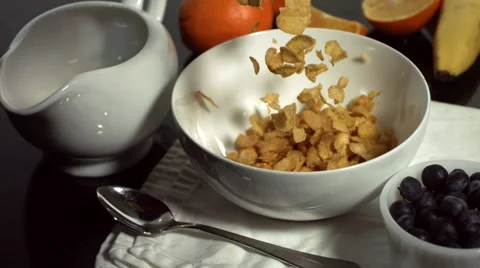 Slow motion shot of cornflakes falling into bowl Stock Footage 67340816