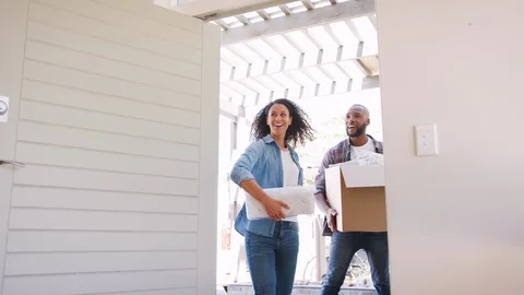 Slow Motion Shot Of Couple Carrying Boxes Into New Home On Moving Day Stock Footage