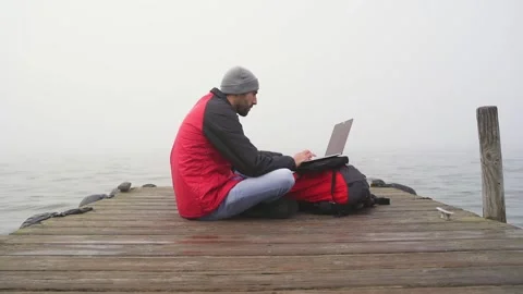Slow motion shot of digital nomad working on wooden pier by ocean Stock Footage 171594462