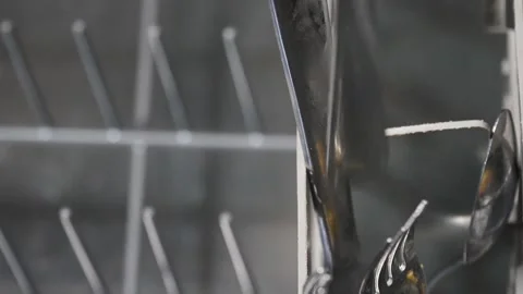 Slow motion shot of a dirty fork being dropped into a dishwasher basket Vídeos de archivo 313907885
