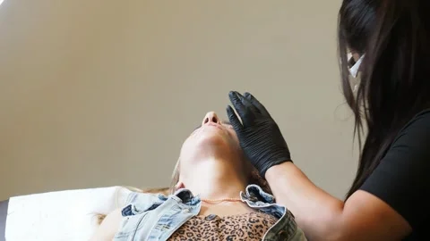 Slow motion shot of esthetician mapping client’s eyebrows using red pencil and Stock Footage 307481678