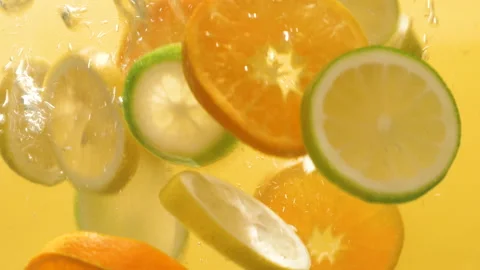 Slow motion shot of falling citrus fruits into water Stock Footage 140248538