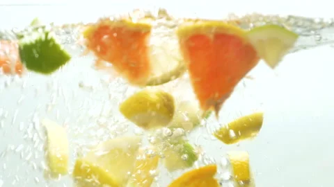 Slow motion shot of falling citrus fruits into water 動画素材 140248649