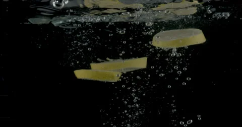 Slow-motion shot of a fresh Lemon being thrown into water. Stock Footage 300496448