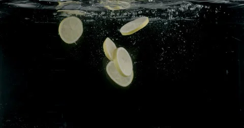 Slow-motion shot of a fresh Lemon being thrown into water. Stock Footage 300497192