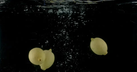 Slow-motion shot of a fresh Lemon being thrown into water. Stock Footage 300502259