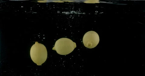 Slow-motion shot of a fresh Lemon being thrown into water. Stock Footage 300502380