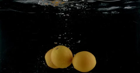 Slow-motion shot of a fresh orange being thrown into water. Stock Footage 300497147