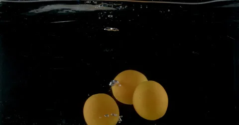Slow-motion shot of a fresh orange being thrown into water. Stock Footage 300497189