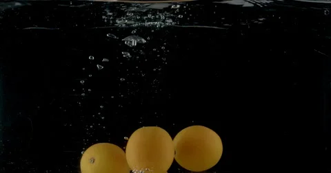Slow-motion shot of a fresh orange being thrown into water. Stock Footage 300502575