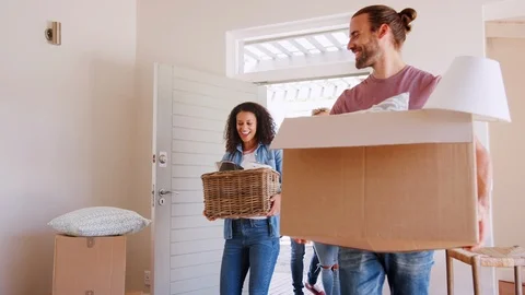 Slow Motion Shot Of Friends Help Couple To Carry Boxes Into New Home On Moving Stock Footage