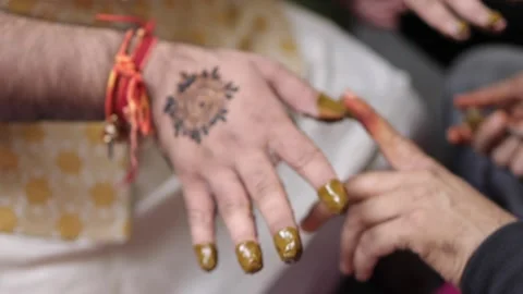 Slow Motion Shot of the groom applying mehendi at his Indian Wedding Stock Footage 169747346