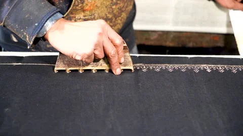 Slow motion shot of handmade block printing on black fabric with gold color  Stock Footage 199272532