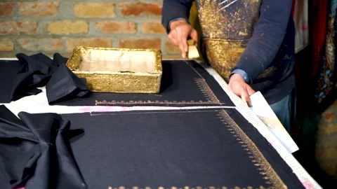 Slow motion shot of handmade block printing on black fabric with gold color  Stock Footage 199272535