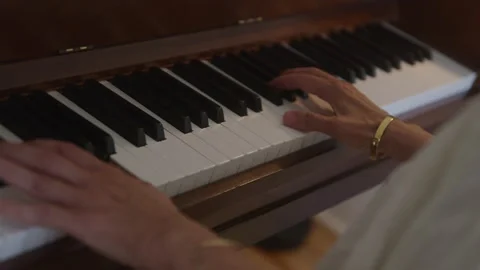 Slow motion shot of Hands On Piano Keys playing song in room, indoors Stock Footage 208792848