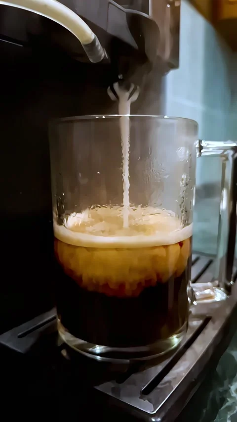 A slow-motion shot of hot coffee mixing with frothed milk to create distinct Stock Footage 336911451