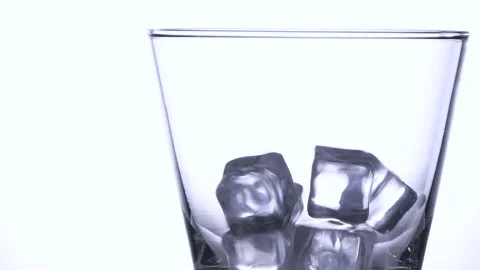 Slow motion shot of ice cubes falling into empty glass Stock Footage 161107307