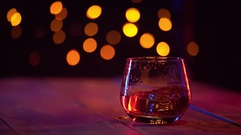 Slow motion shot of ice cubes falling into glass of whiskey. Stock Footage 319028149