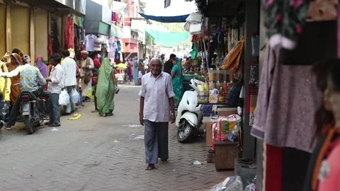 Slow-motion shot of Indian old man walking at busy street market in India. Stock Footage 240735990