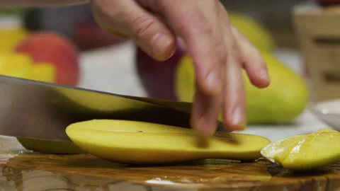 Slow motion shot of knife slicing mango and cutting squares in slice Stock Footage 341240179