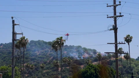Slow motion shot of LAFD responding to wildfire with aerial unit Stock Footage 335975696