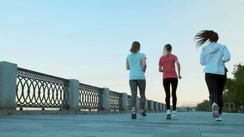 Slow motion shot of the legs of three girls friends morning run Stockbeeldmateriaal 119019681