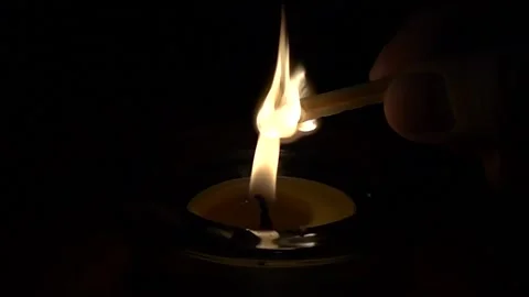 Slow motion shot of lighting a match on a burning candle flame Stock Footage 230326159