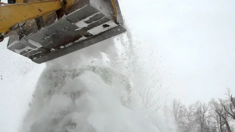 Slow Motion Shot Of Loader Falling Snow On Rolled Hay In Park Against Clear Sky Stock Footage 223262340